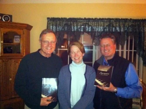 Book club members holding copies of a book with visiting author Elizabeth Caulfield