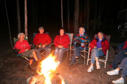 CWN members in camp chairs around a campfire at night