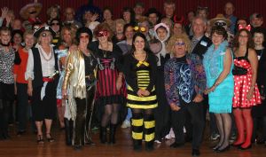 A big group of CWN members in colorful costumes at a party