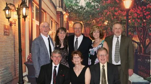 CWN members dressed up for an evening dance, posing in a festively lit hall