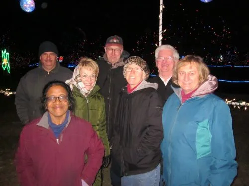 Smiling CWN members bundled in jackets at a holiday light show