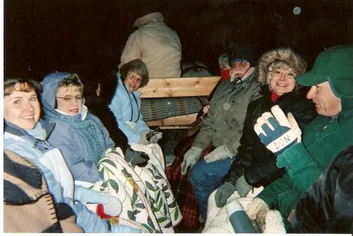 CWN members bundled in blankets and winter hats on a sleigh ride