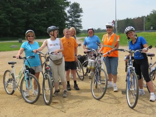 Six CWN cyclists in helmets standing with their bikes